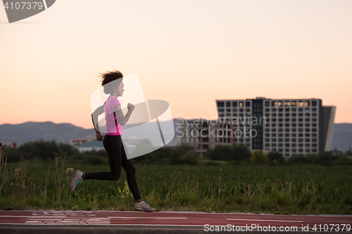 Image of a young African American woman jogging outdoors