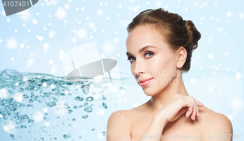 Image of beautiful young woman face over water and snow
