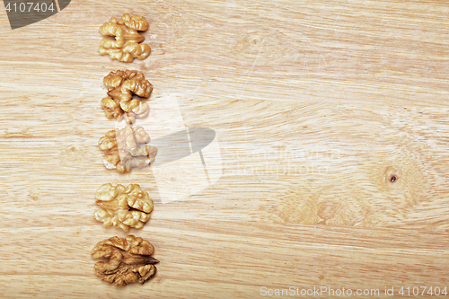 Image of Row of walnuts on plank