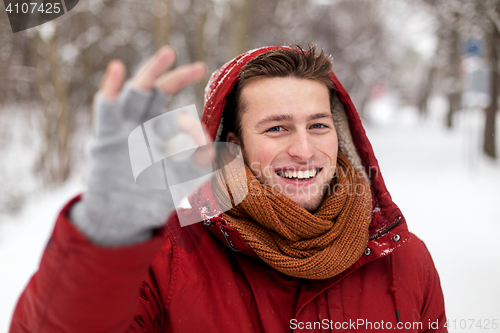 Image of happy man in winter jacket showing ok hand sign