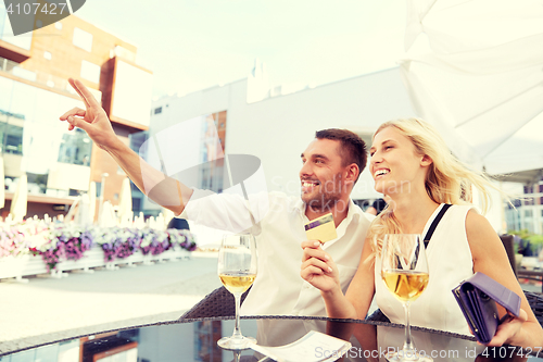 Image of happy couple with wallet paying bill at restaurant