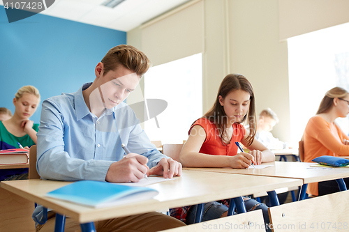 Image of group of students with books writing school test