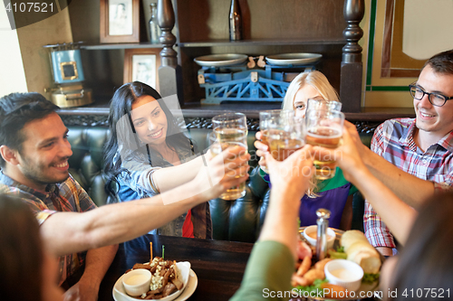 Image of happy friends drinking beer at bar or pub