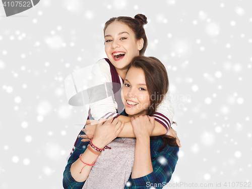 Image of happy smiling teenage girls hugging over snow