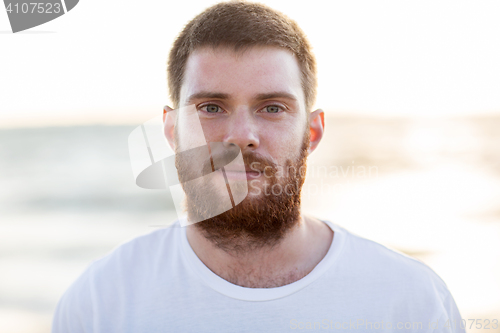 Image of face of happy smiling young man on beach