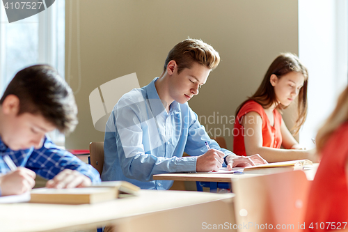 Image of group of students with books writing school test