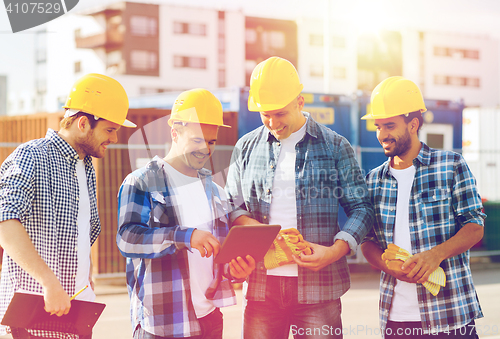 Image of group of smiling builders with tablet pc outdoors