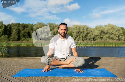 Image of man making yoga in scale pose outdoors