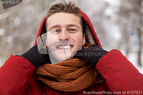 Image of happy man in winter jacket and scarf outdoors