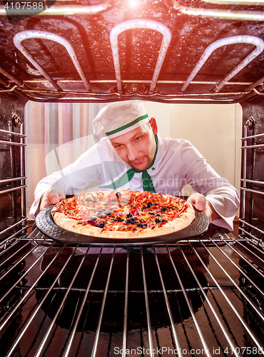 Image of Chef cooking pizza in the oven.