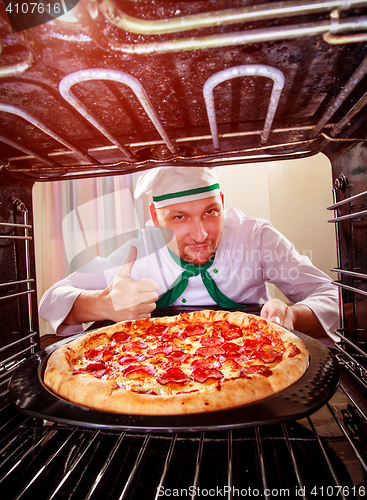 Image of Chef cooking pizza in the oven.