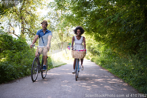 Image of Young multiethnic couple having a bike ride in nature