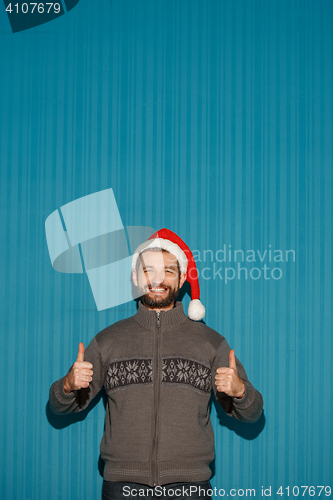 Image of Smiling christmas man wearing a santa hat