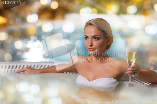 Image of happy woman drinking champagne at swimming pool