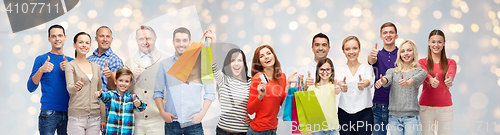 Image of happy people with shopping bags showing thumbs up