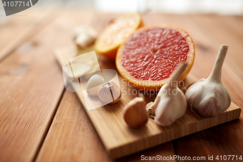 Image of garlic and grapefruit on wooden board