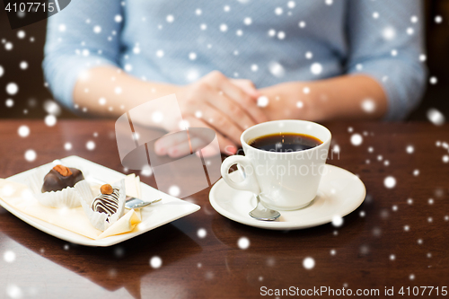 Image of close up of woman hands with coffee and dessert