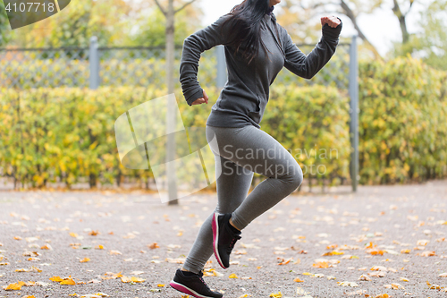 Image of close up of young woman running in autumn park