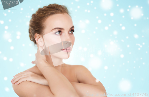 Image of beautiful young woman face and hands over snow