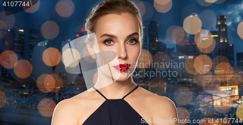 Image of beautiful woman in black over dark background