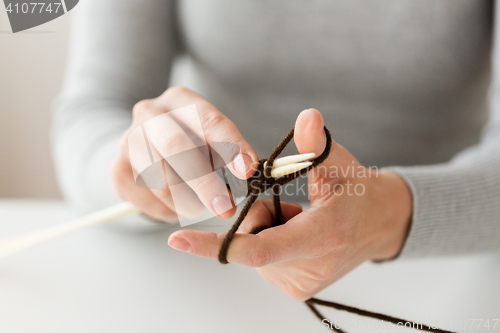 Image of close up of hands knitting with needles and yarn