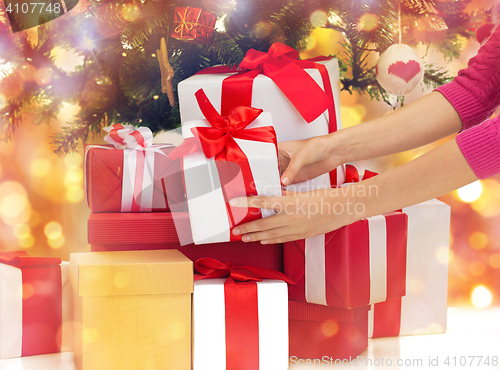 Image of close up of woman with gifts and christmas tree