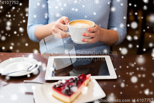 Image of woman with coffee, tablet pc and cake