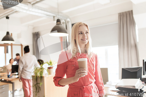 Image of happy creative female office worker with coffe cup