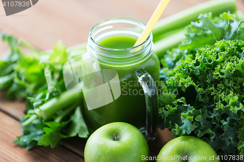 Image of close up of jug with green juice and vegetables