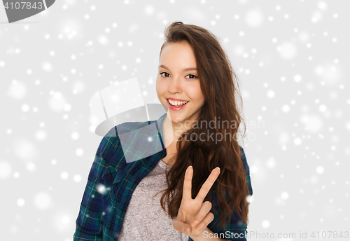 Image of happy smiling teenage girl showing peace sign