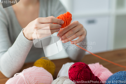 Image of woman pulling yarn up into ball