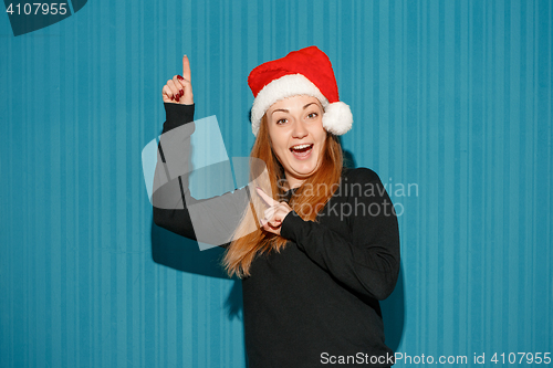 Image of Surprised christmas girl wearing a santa hat