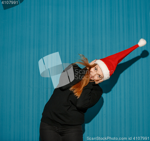 Image of Surprised christmas girl wearing a santa hat