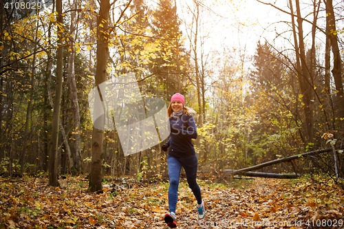 Image of Slender woman running in park