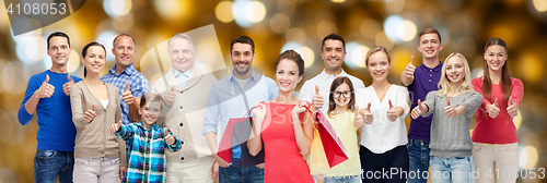 Image of happy people with shopping bags showing thumbs up