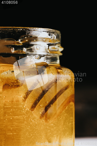 Image of Close up of honey stick in jar