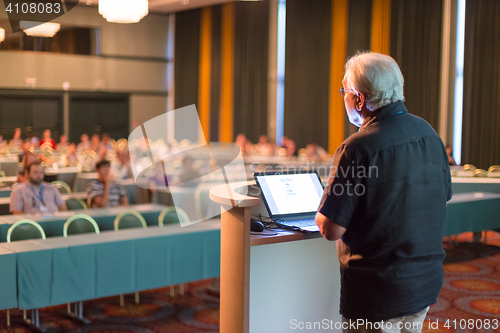 Image of Senior public speaker giving talk at scientific conference.