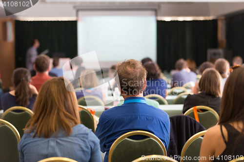 Image of Audience in lecture hall participating at business conference.