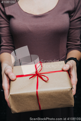 Image of Crop hands holding wrapped present