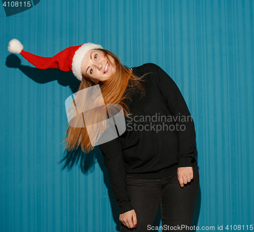 Image of Surprised christmas girl wearing a santa hat