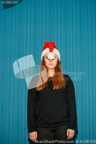 Image of Funny christmas girl wearing a santa hat