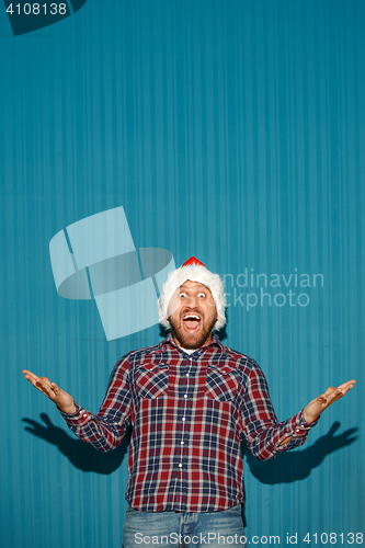 Image of Surprised christmas man wearing a santa hat