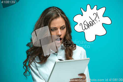 Image of Surprised young business woman with pen and tablet for notes on blue background