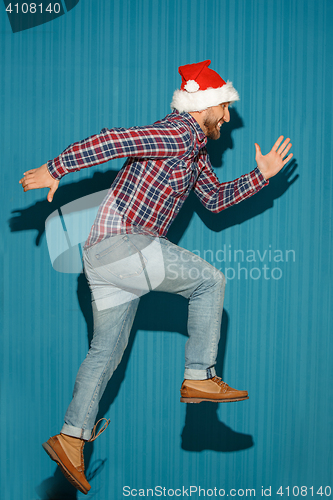 Image of The running christmas man wearing a santa hat