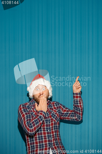 Image of Surprised christmas man wearing a santa hat