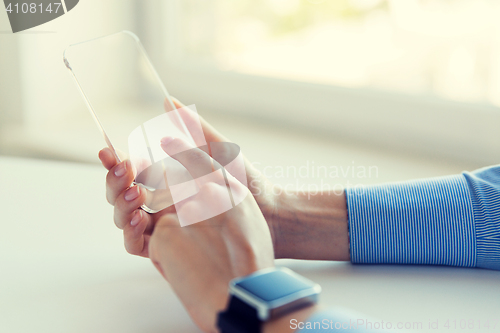 Image of close up of hands with smart phone and watch