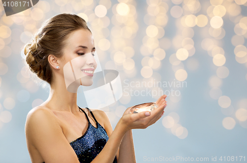 Image of smiling woman in evening dress holding diamond