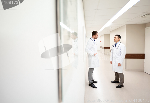 Image of male doctors talking at hospital corridor