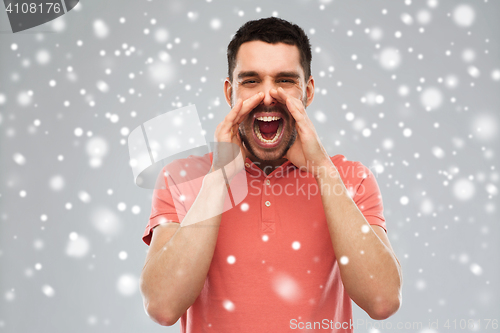 Image of angry shouting man in t-shirt over snow background