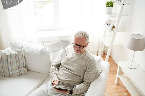 Image of senior man with tablet pc at home